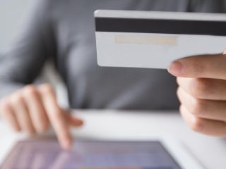 Femme procédant à un achat a l'aide de sa carte de crédit