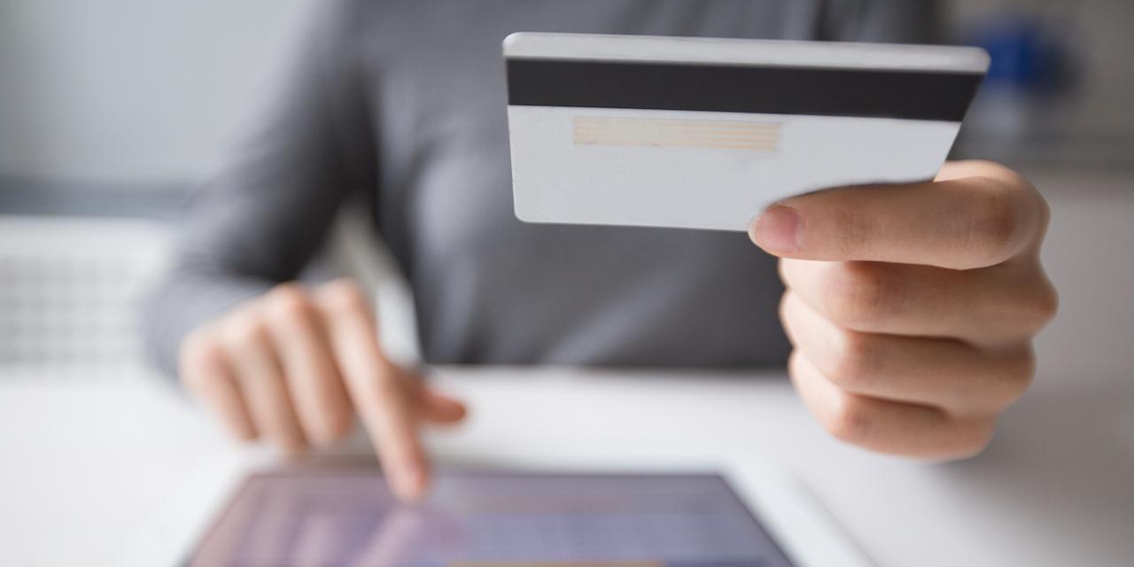 Femme procédant à un achat a l'aide de sa carte de crédit