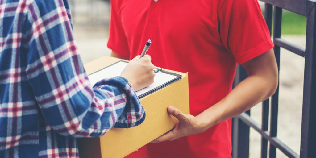 Jeune homme donnant un colis à un client