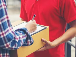 Jeune homme donnant un colis à un client